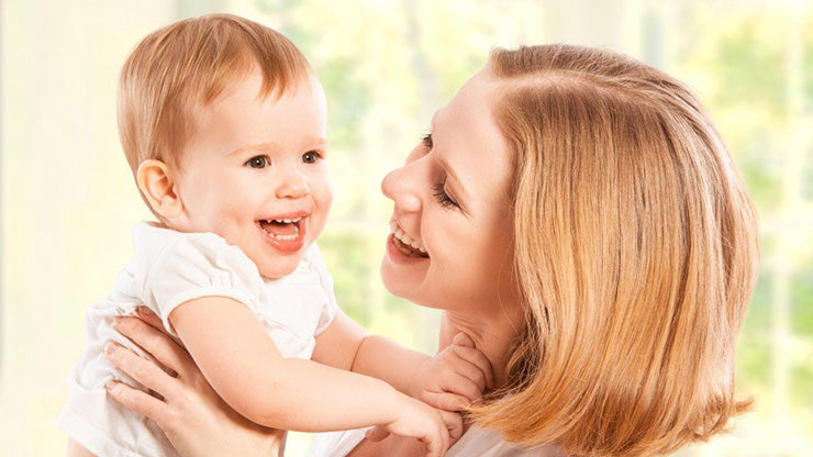 Smiling mom holding toddler in the air