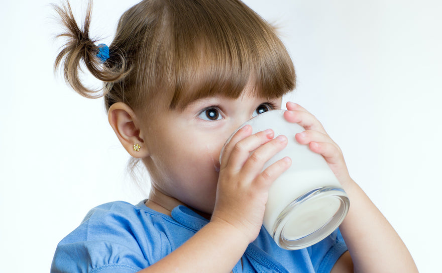 Toddler drinking milk from a glass