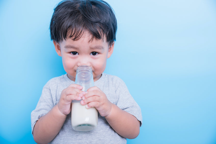 Toddler drinking milk from glass