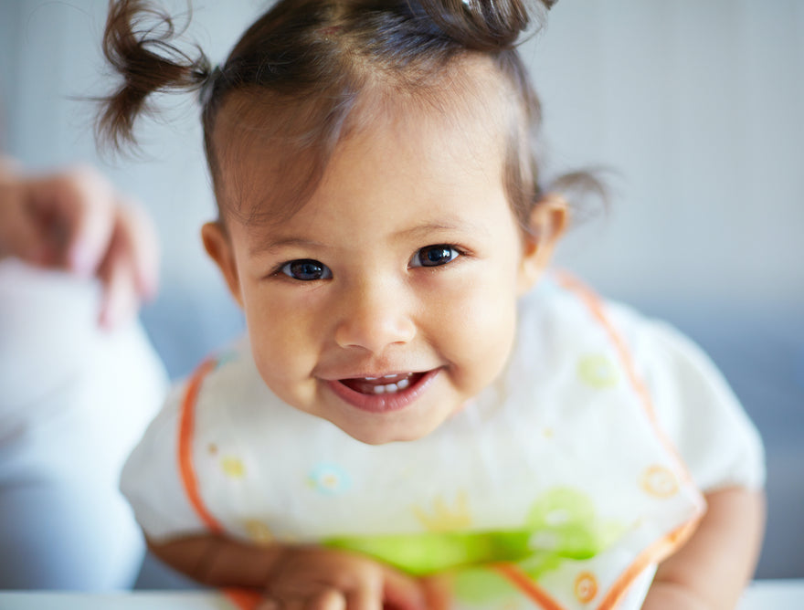 Baby girl smiling wearing a bib