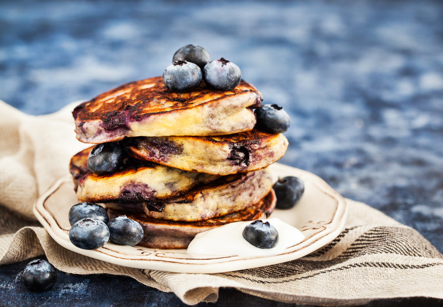 Stack of pancakes with blueberries and cream