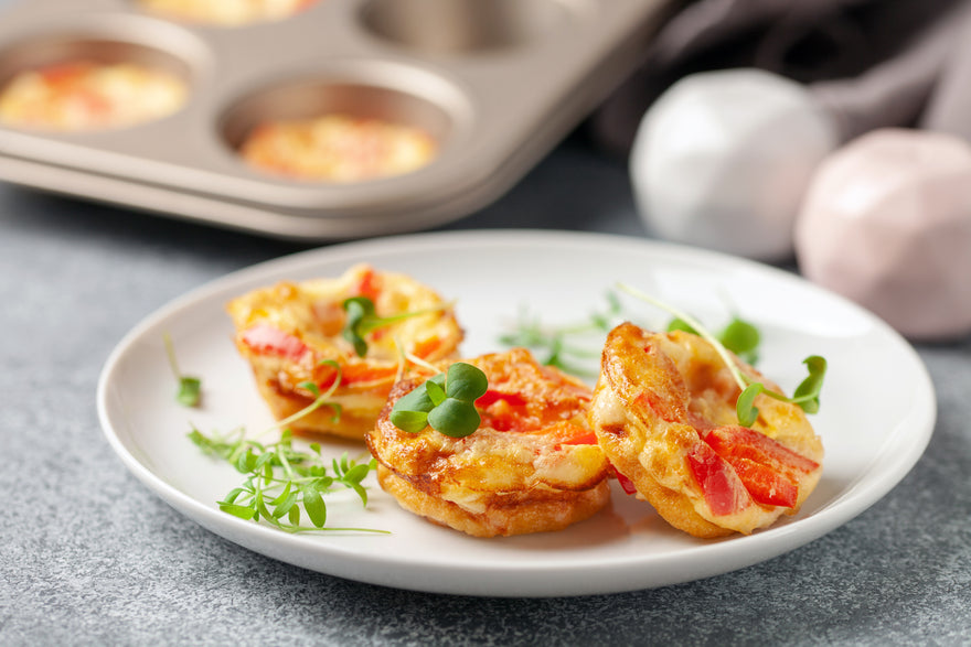 Egg bites on a white plate garnished with greens