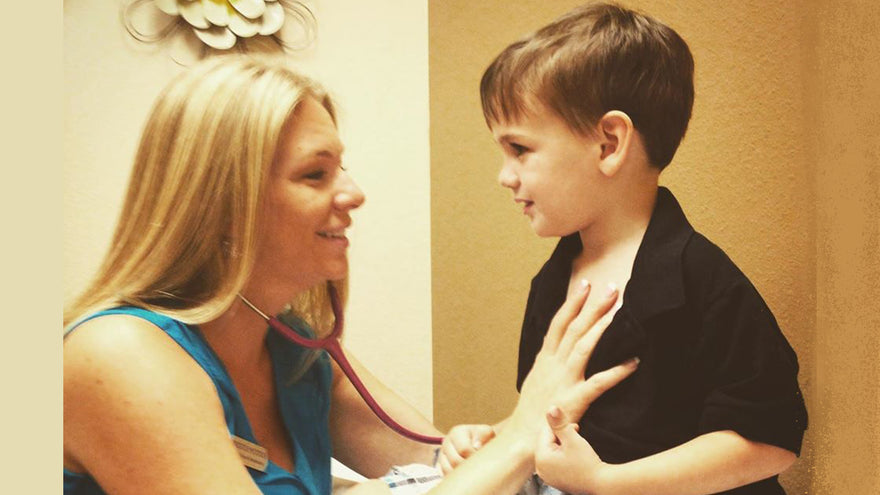 Healthcare professional checks son's heartbeat with stethoscope