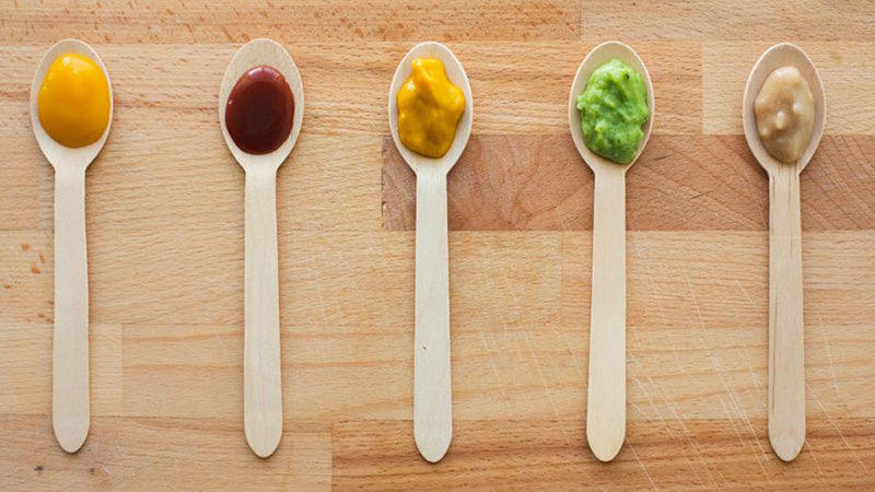Variety of baby food purees on spoons