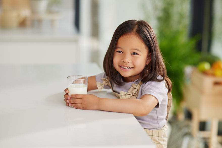 Girl enjoying a glass of Kabrita Junior at the kitchen table