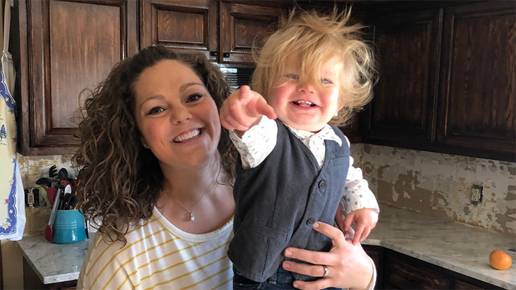 Young mom and toddler son smiling and pointing at camera