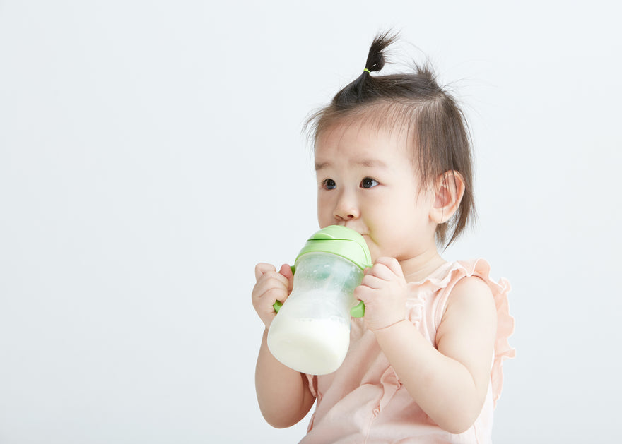 Toddler girl drinking milk from sippy cup