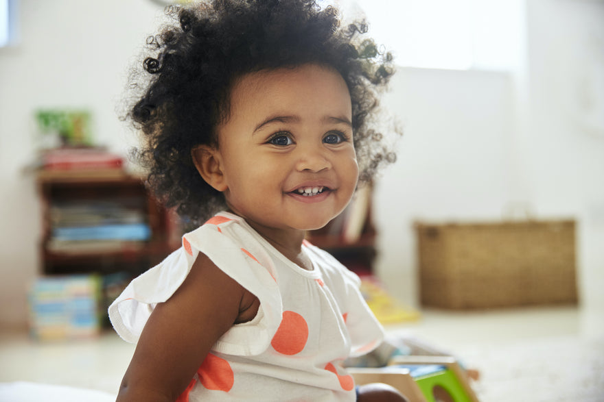 Smiling toddler playing with toys in playroom