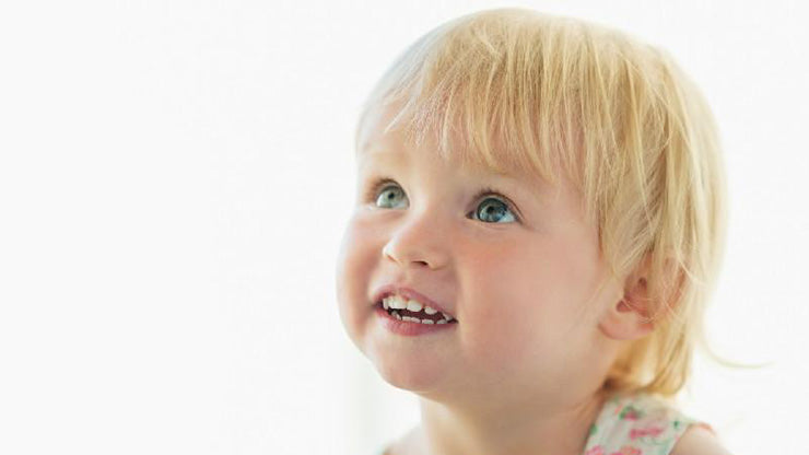 Blonde-haired blue-eyed toddler smiling